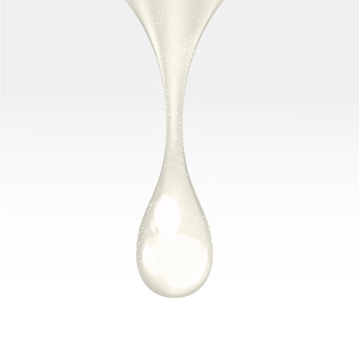 Close-up of a white liquid droplet on a light gray background