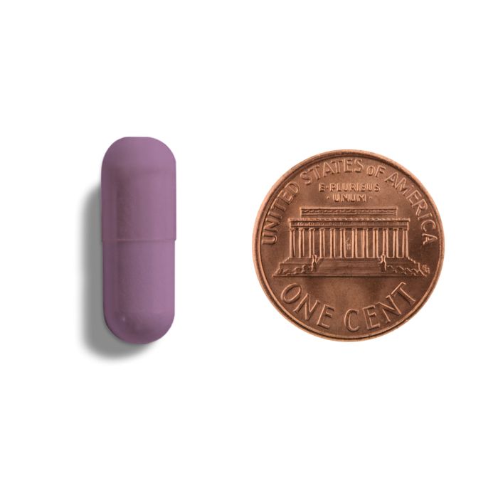 Purple lip balm next to a copper penny on a white background