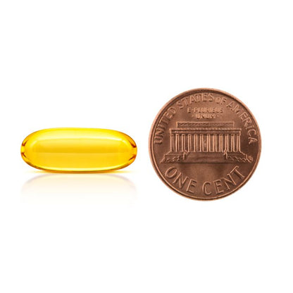 Yellow capsule next to a U.S. penny on a white background