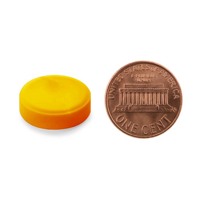 Yellow cap next to a copper penny on a white background