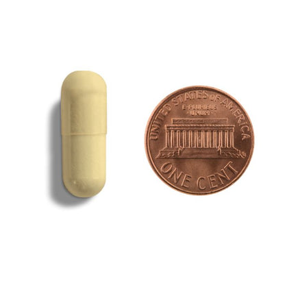 Yellow capsule next to a U.S. penny on a white background
