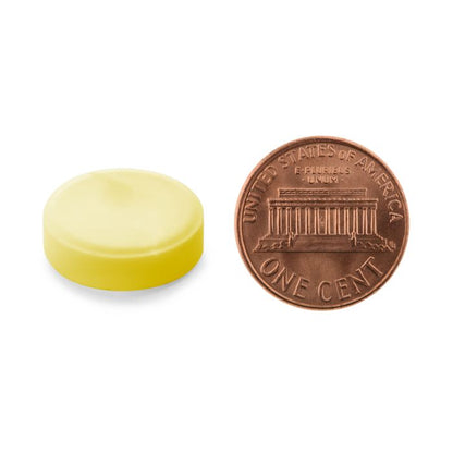 Yellow cap next to a copper penny on a white background