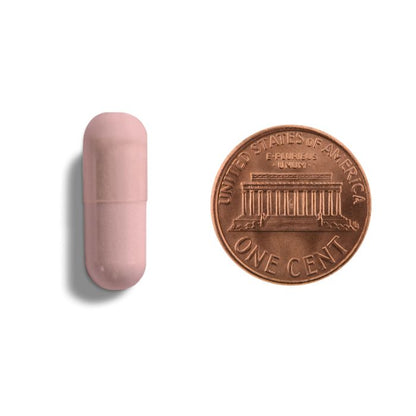 Pink cylindrical object next to a copper penny on a white background