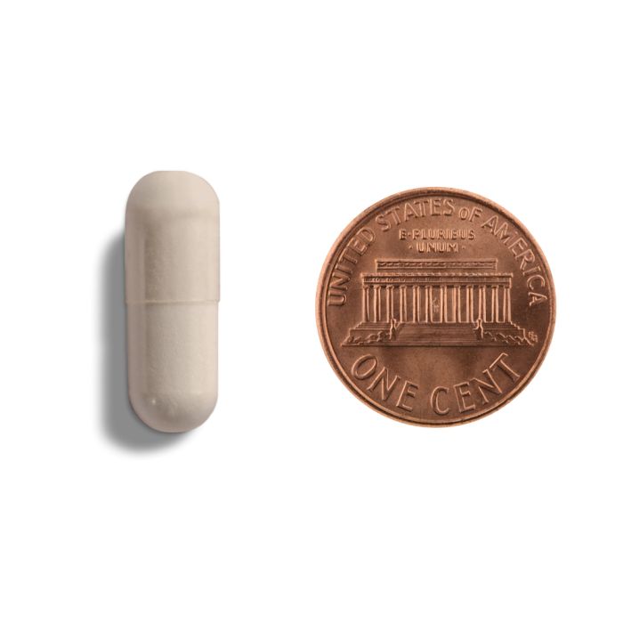 Copper penny and beige capsule on a white background