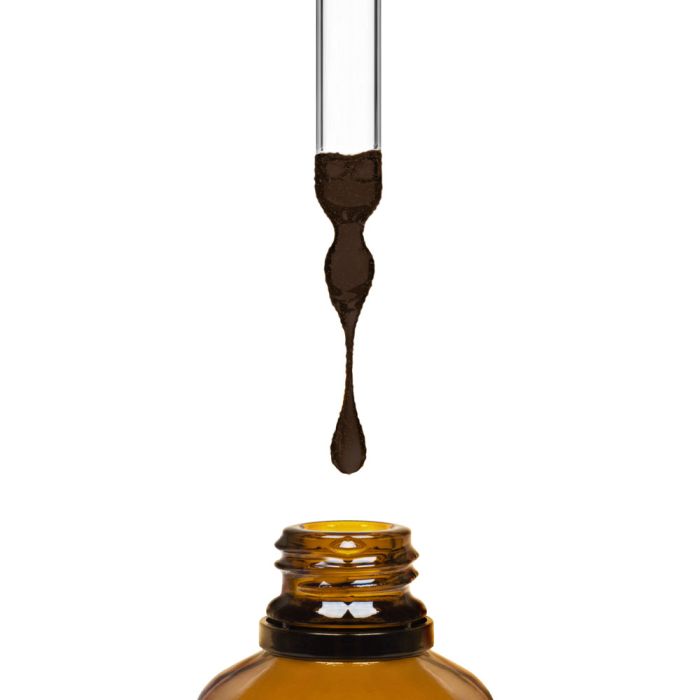 Amber glass dropper bottle with a droplet of liquid on a white background