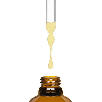 dropper with yellow liquid dripping into a brown bottle on a white background