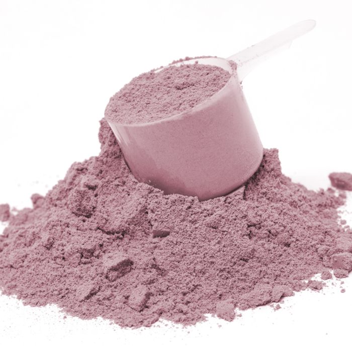 Pink powder in a scoop on a white background