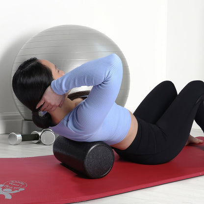 A woman demonstrating the use of the foam roller.  