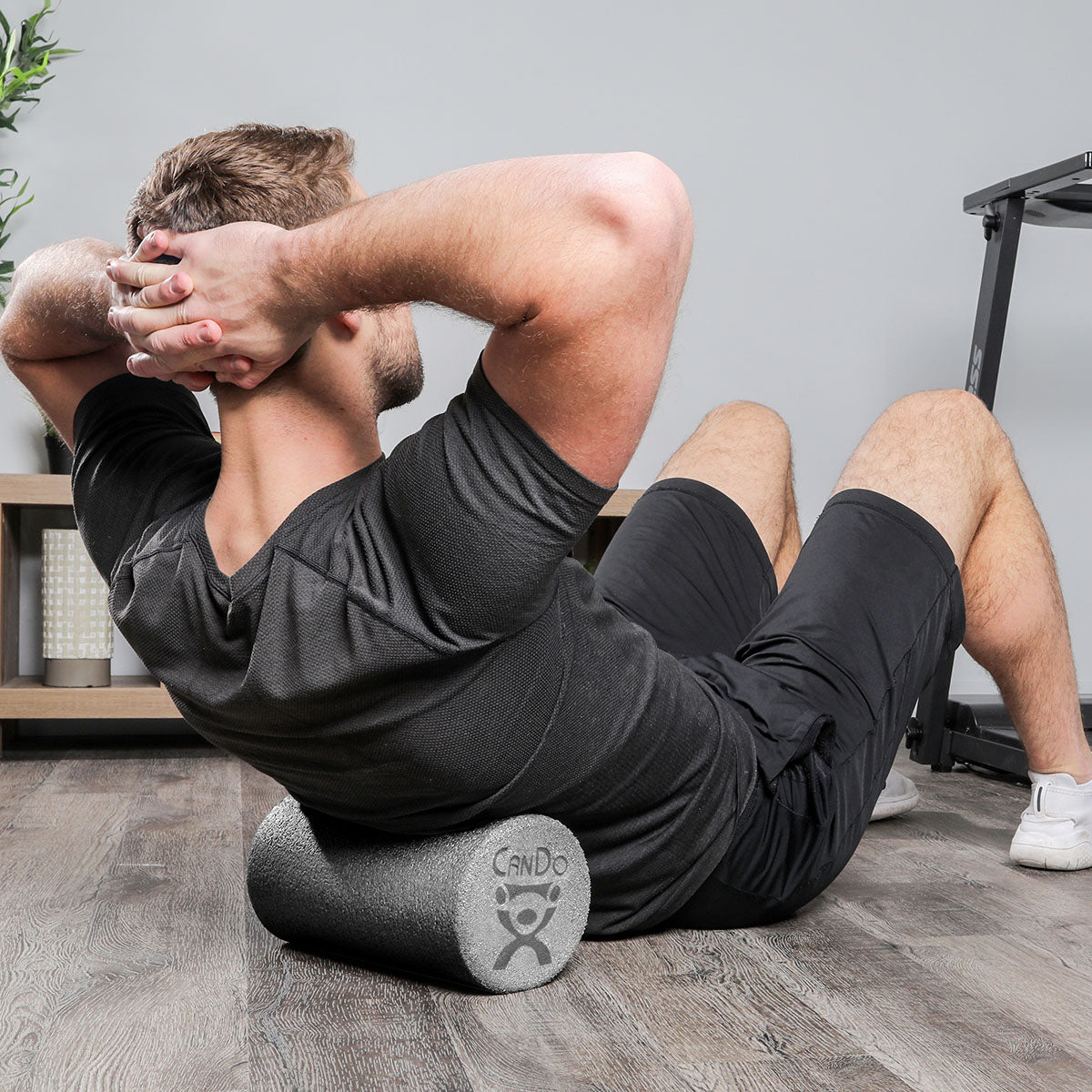 A man demonstrating the use of the foam roller.  