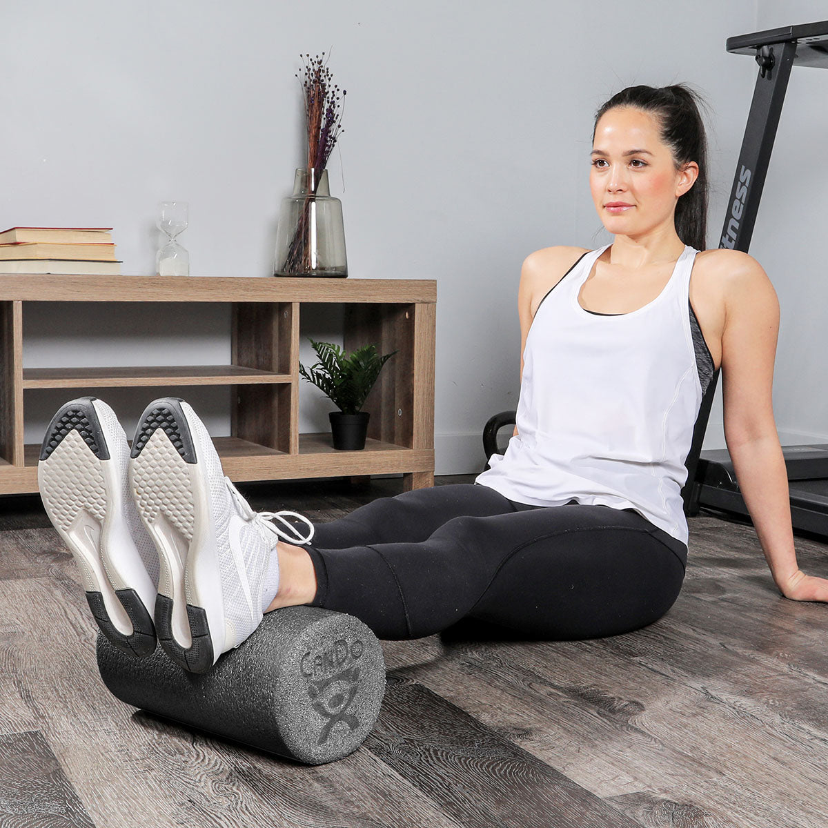 A woman demonstrating use of the foam roller