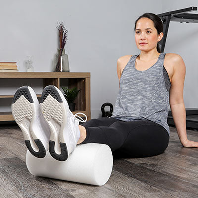 A woman demonstrating the use of the foam roller.  