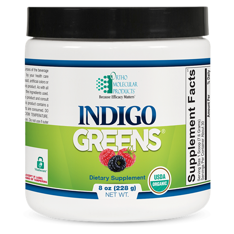 A container of Orthomolecular Products Indigo Greens Powder, which is a dietary supplement designed to provide a full-spectrum of superfoods including organic berries, vegetables, and greens.
