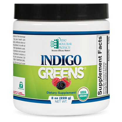 A container of Orthomolecular Products Indigo Greens Powder, which is a dietary supplement designed to provide a full-spectrum of superfoods including organic berries, vegetables, and greens.