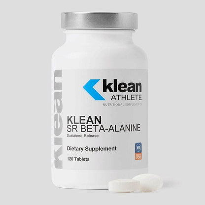 A bottle of Klean SR Beta-Alanine with 100 tablets displayed in front of it. The bottle is white with a blue and grey label, and the tablets are white.