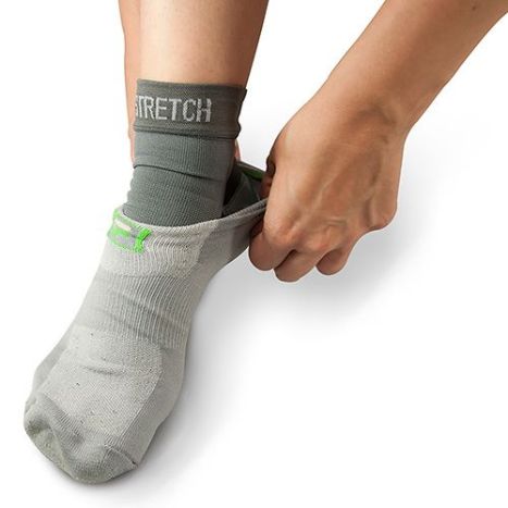 Person putting on a gray ankle sock with 'STRETCH' text on a white background